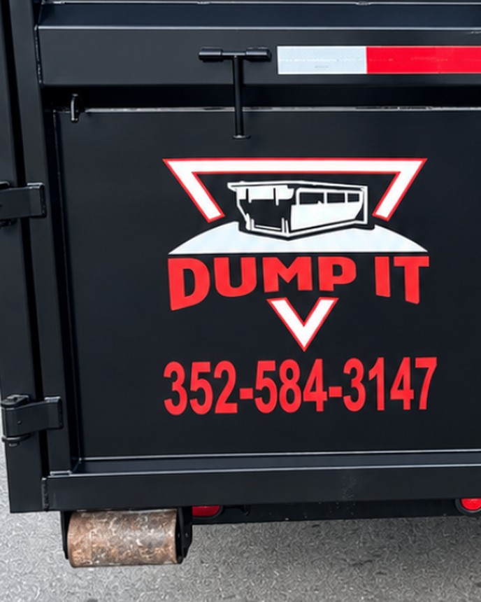 The Dump It logo and the phone number 352-584-3147 painted in red on the rear door of a container