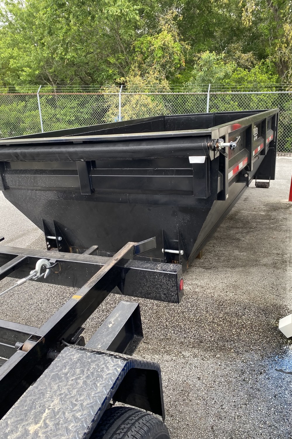 A Dump It container riding tilted on the trailer bed, ready to haul away